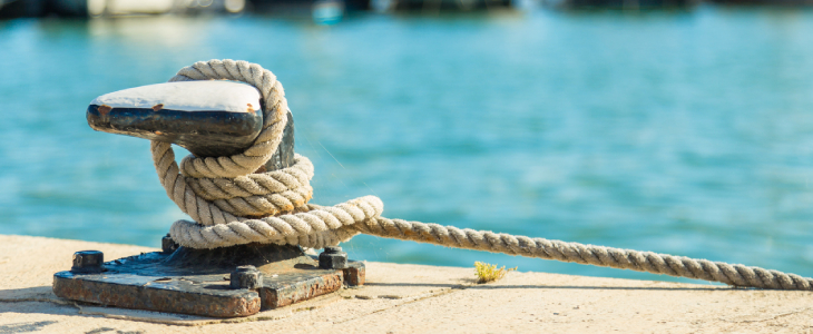 Mooring rope and bollard on sea water and yachts